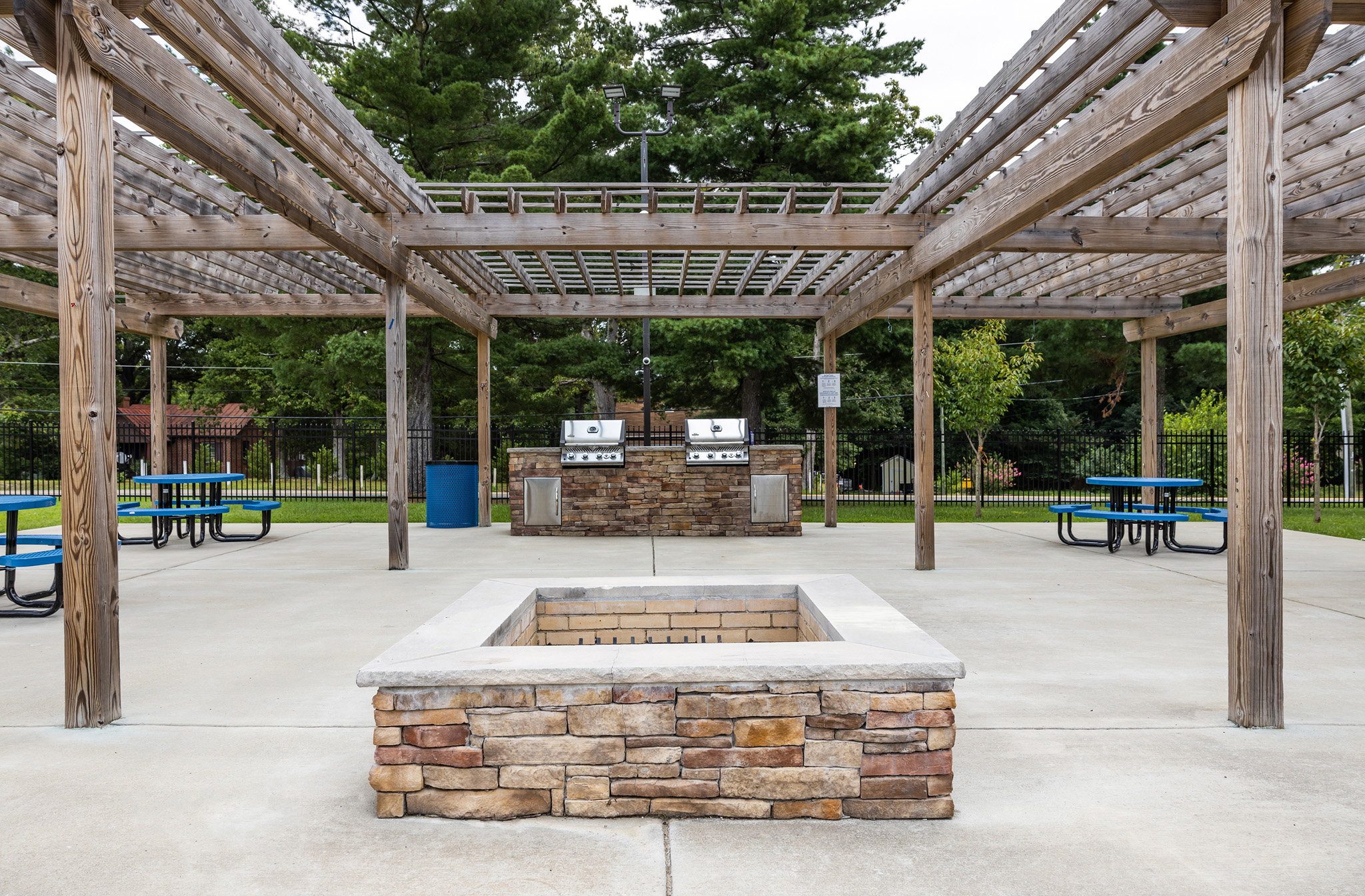 a fountain in a park with benches and a pavilion